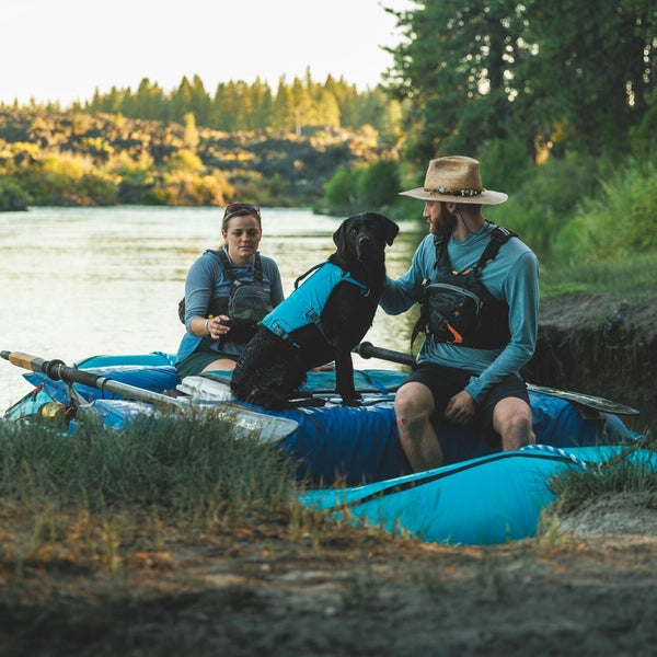 Eddy the lab sits with her humans in their raft.