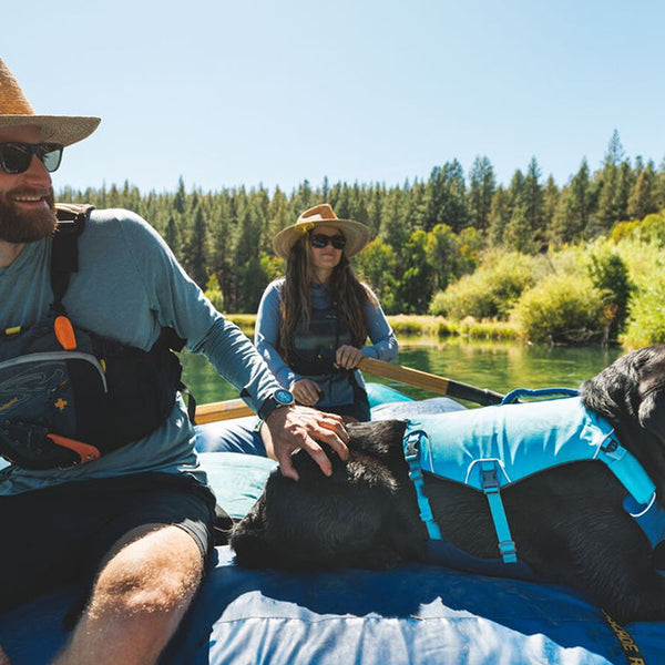 A man pets a dog on a raft