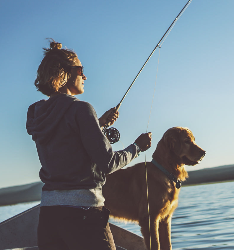 Linsey fishes with Chimmy at her side in the boat.