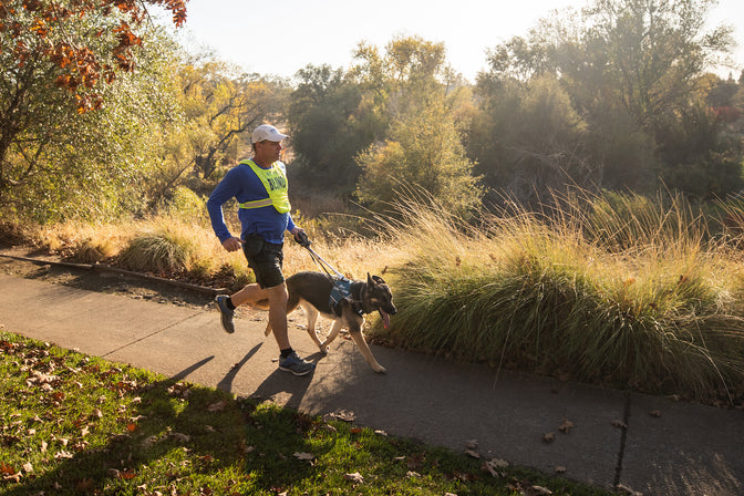Blind runner runs on path with dog.