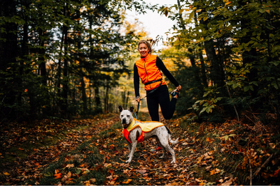 Woman hiking with her dog in the fall.