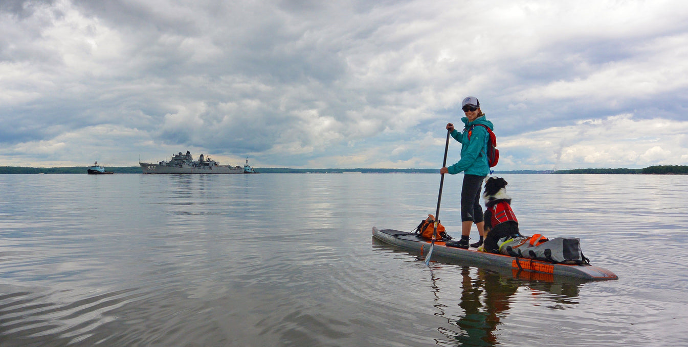 Maria and dog in Float Coats on stand up paddleboard.