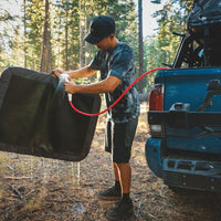 A man washes off his Dirtbag™ Bed with a hose.