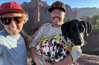 Dani, Brian and Vilas smile at the camera during a hike in Moab.