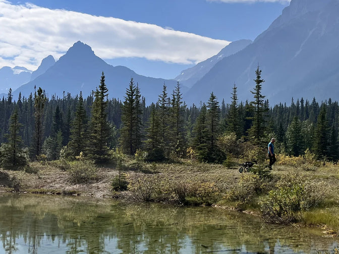 A man and his dog hike in the Canadian Rockies.