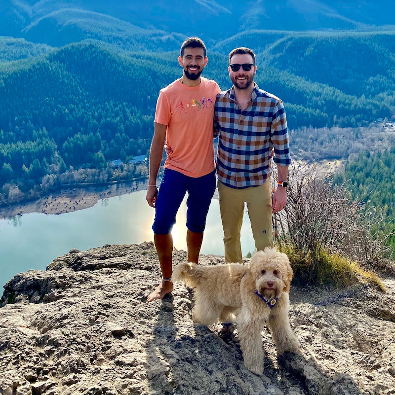 Cory & Rafa with Bondi on a mountain ridge overlooking a turquoise lake.