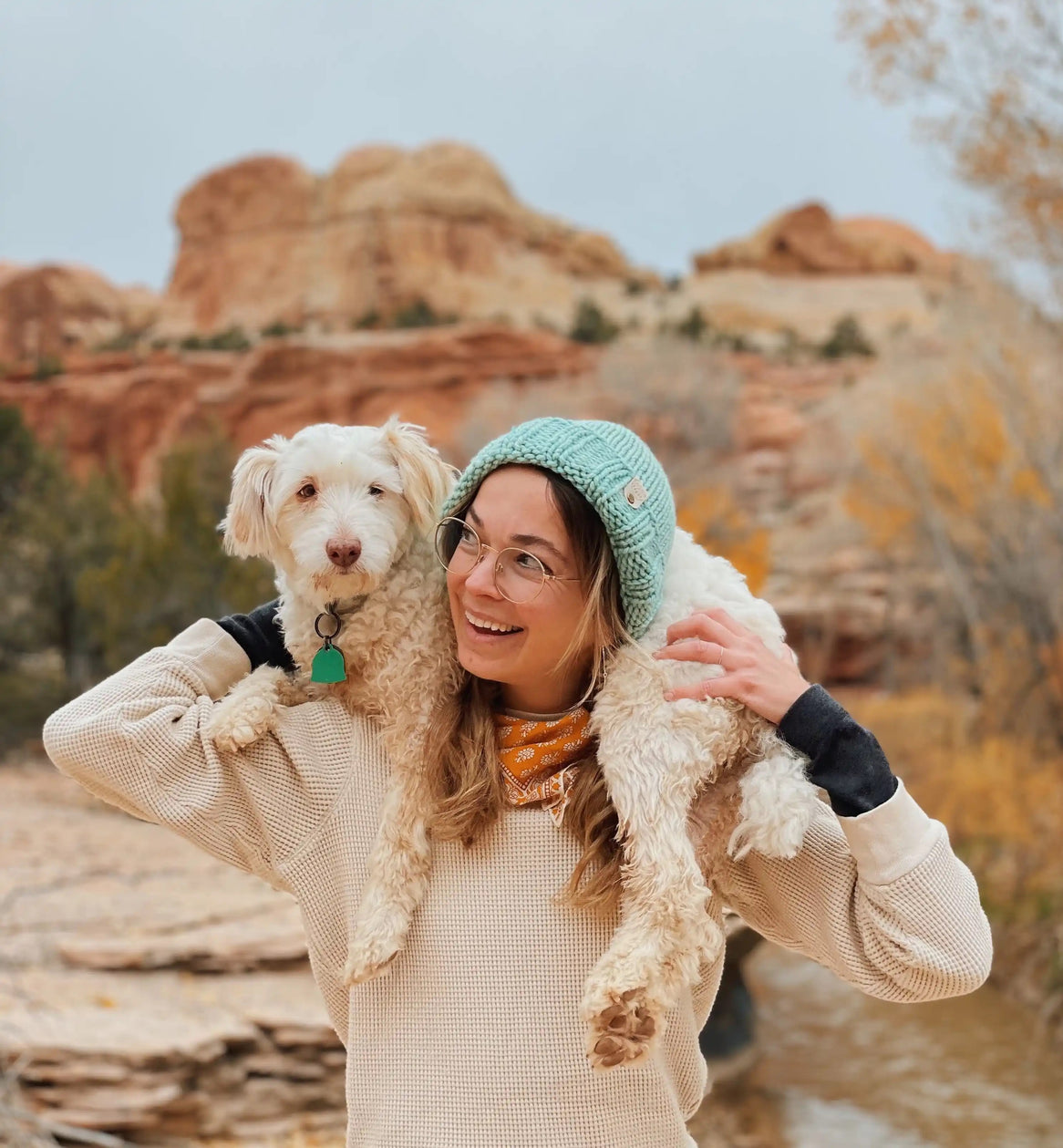 Katie and Spaghetti, her dog in the desert on her shoulders.