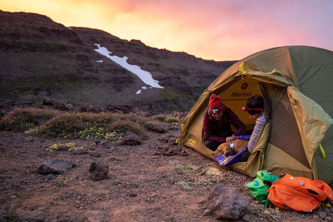 Two women with dog camp in the Steens mountains at sunset.